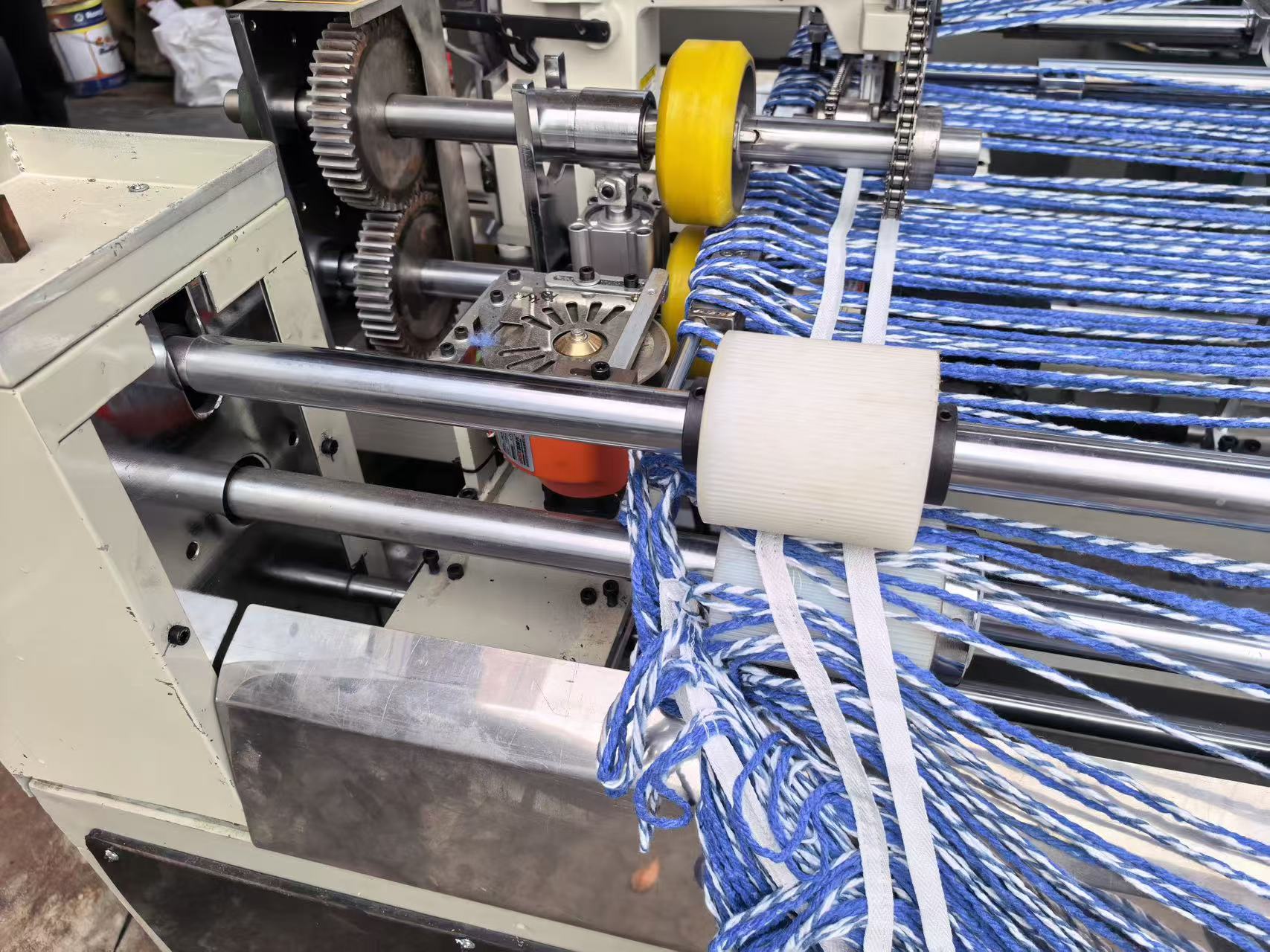 Proceso automático de fabricación de mopas en lazo con hilo alineado y bandas de retención